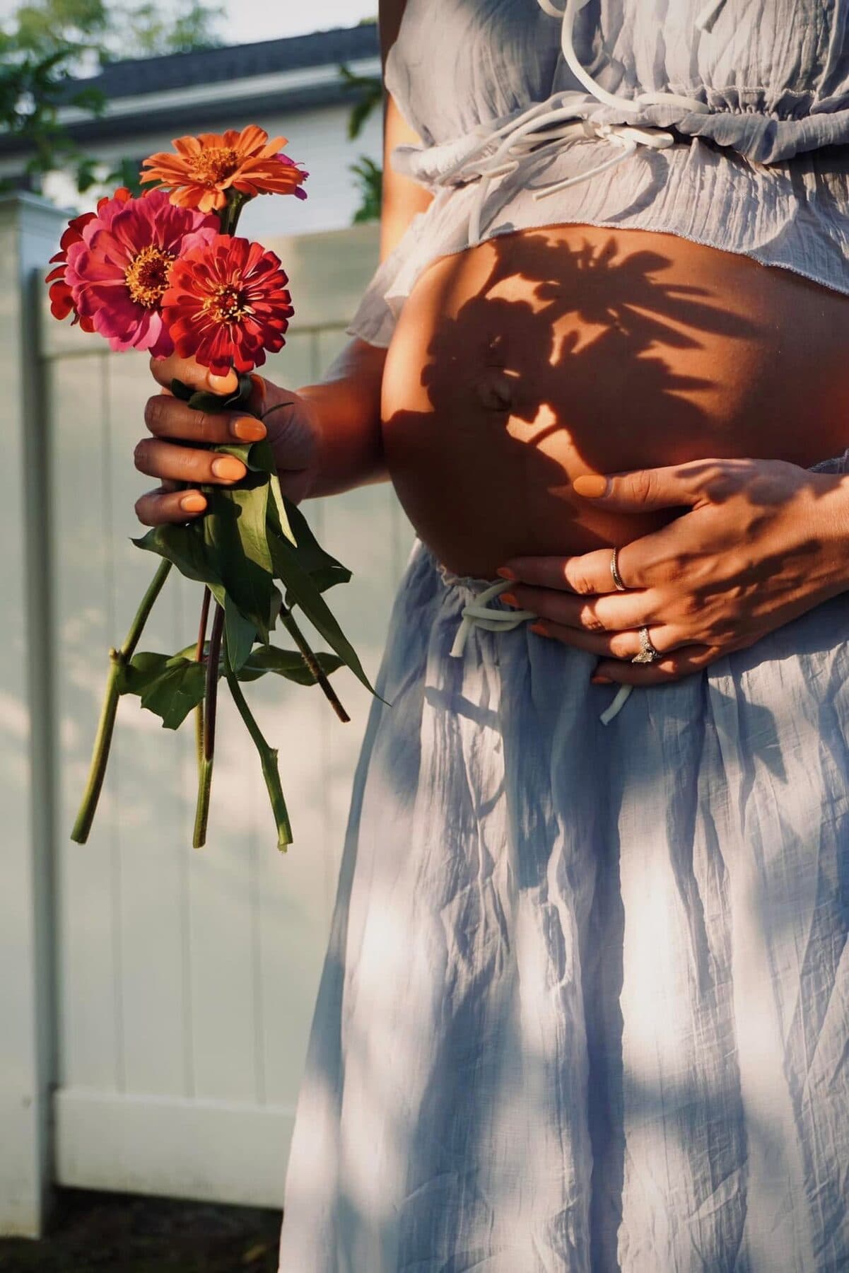 A flower’s shadow across an expecting belly