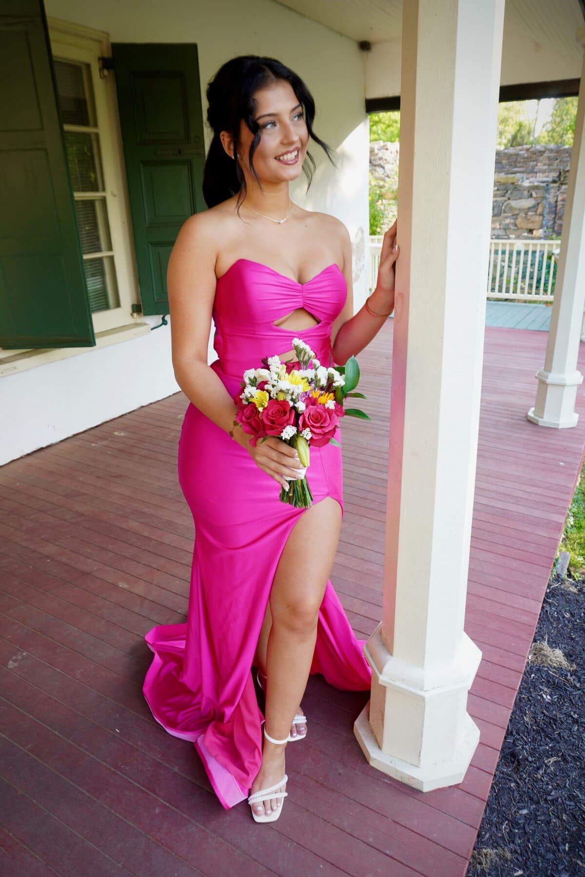A pink gown beside a white column