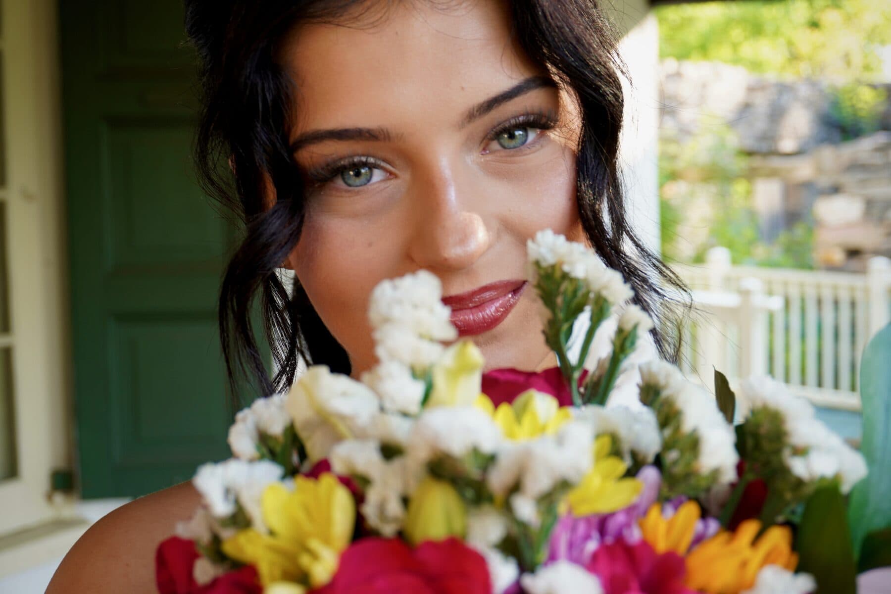 A close portrait behind a colorful bouquet