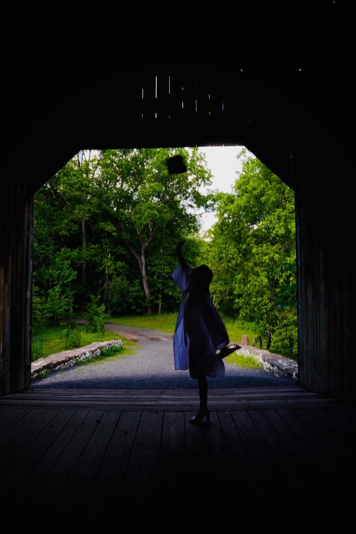 Silhouette tossing a cap in a covered bridge